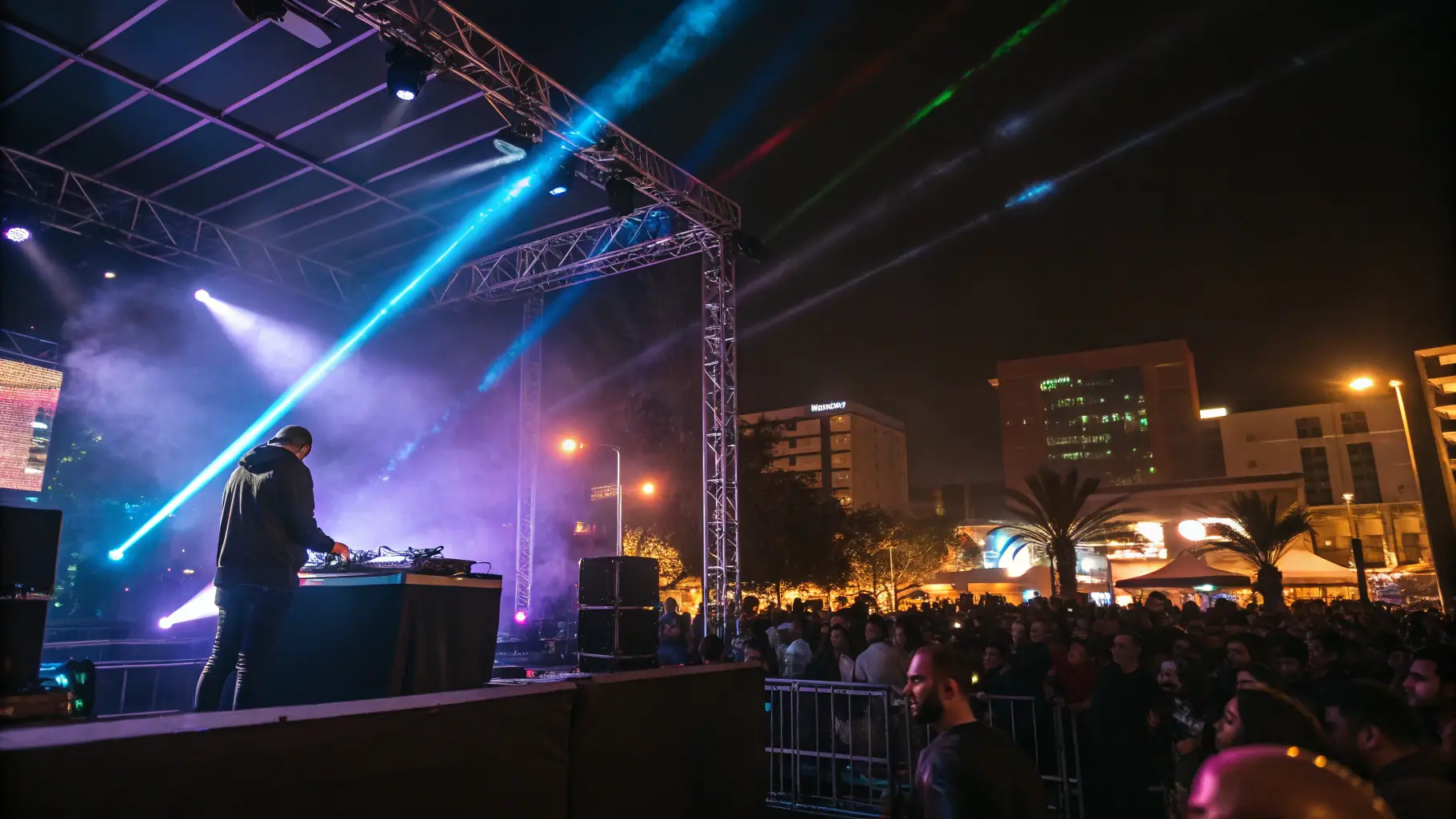 A live performance of a hip hop concert with a DJ and dancers on stage.